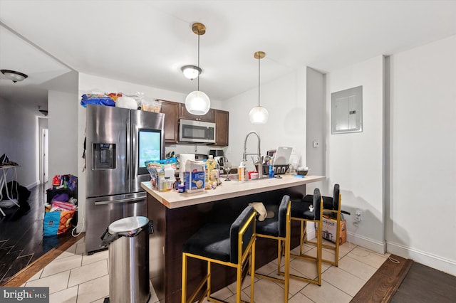 2467 79th Ave, Philadelphia, PA 19150 - kitchen featuring appliances with stainless steel finishes, light countertops, electric panel, a breakfast bar area, and decorative light fixtures