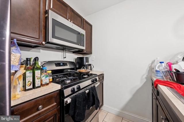 2467 79th Ave, Philadelphia, PA 19150 - kitchen with appliances with stainless steel finishes, dark brown cabinetry, light tile patterned floors, and light countertops