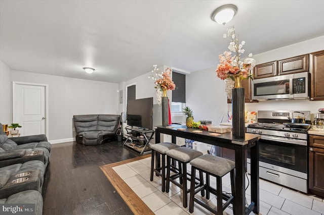 2467 79th Ave, Philadelphia, PA 19150 - kitchen with appliances with stainless steel finishes, open floor plan, light wood-style flooring, and dark brown cabinets