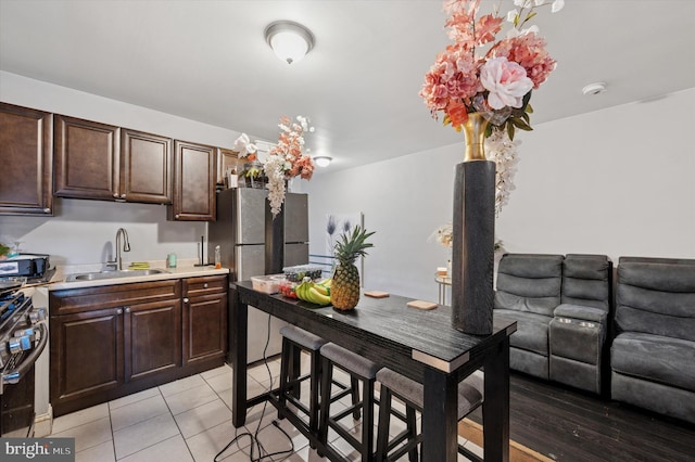 2467 79th Ave, Philadelphia, PA 19150 - kitchen with stainless steel appliances, light countertops, dark brown cabinetry, and light tile patterned floors