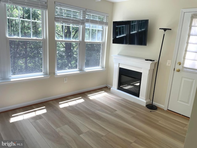 1103 Jousting Way, Mount Airy, MD 21771 - unfurnished living room with a glass covered fireplace, healthy amount of natural light, and light wood-type flooring
