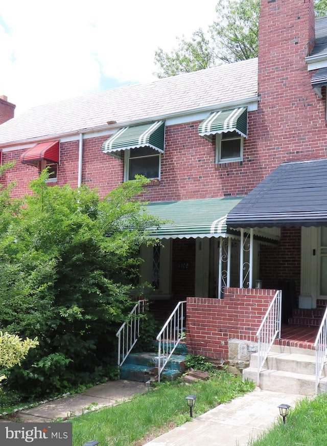 4102 The Alameda, Baltimore, MD 21218 - view of front of home featuring brick siding, a chimney, and covered porch