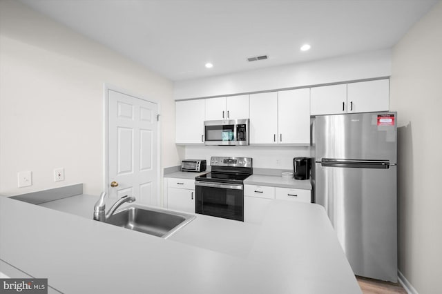 39334 Tall Pines Ct Unit 15001, Bethany Beach, DE 19930 - kitchen featuring appliances with stainless steel finishes, white cabinetry, light countertops, recessed lighting, and light wood finished floors