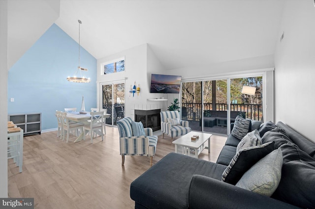 39334 Tall Pines Ct Unit 15001, Bethany Beach, DE 19930 - living area featuring high vaulted ceiling, a chandelier, healthy amount of natural light, light wood-type flooring, and a fireplace