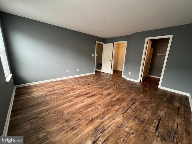 11002 Koman Cir Unit 202, Manassas, VA 20109 - unfurnished bedroom with dark wood-style flooring, a spacious closet, and a closet