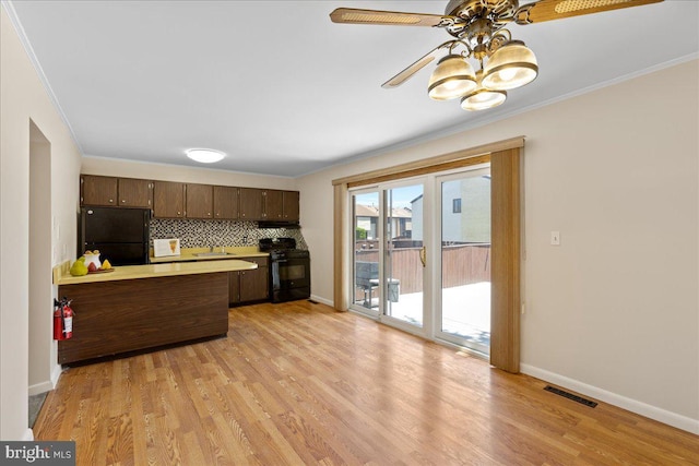 206 Canterbury Ct, Hightstown, NJ 08520 - kitchen with black appliances, crown molding, dark brown cabinetry, light wood-style flooring, and backsplash