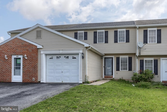 206 Lighthouse Dr, Jonestown, PA 17038 - townhome / multi-family property featuring a garage, driveway, a front yard, and brick siding