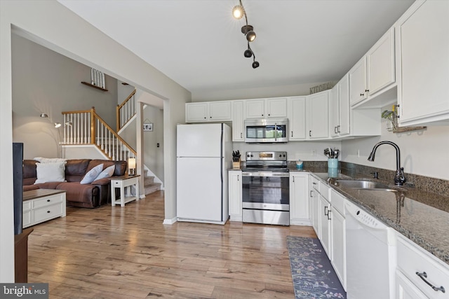 2405 Carriage Ln, Royersford, PA 19468 - kitchen featuring appliances with stainless steel finishes, dark stone counters, light wood finished floors, and white cabinetry