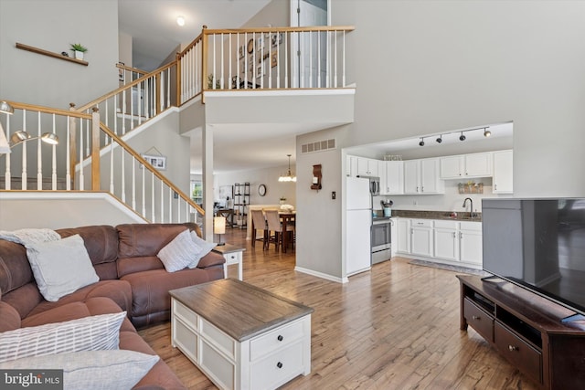 2405 Carriage Ln, Royersford, PA 19468 - living area featuring a towering ceiling, light wood-style flooring, and stairway