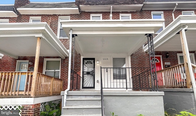 2217 Riggs Ave, Baltimore, MD 21216 - entrance to property with brick siding, a porch, and roof with shingles