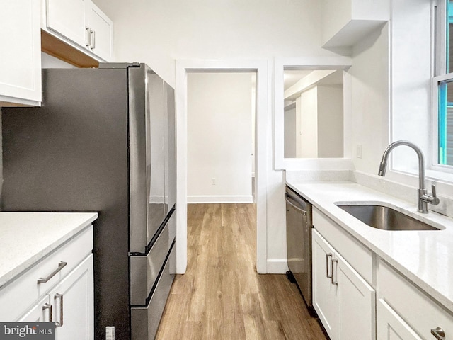 2217 Riggs Ave, Baltimore, MD 21216 - kitchen featuring stainless steel appliances, light wood-style floors, and white cabinets