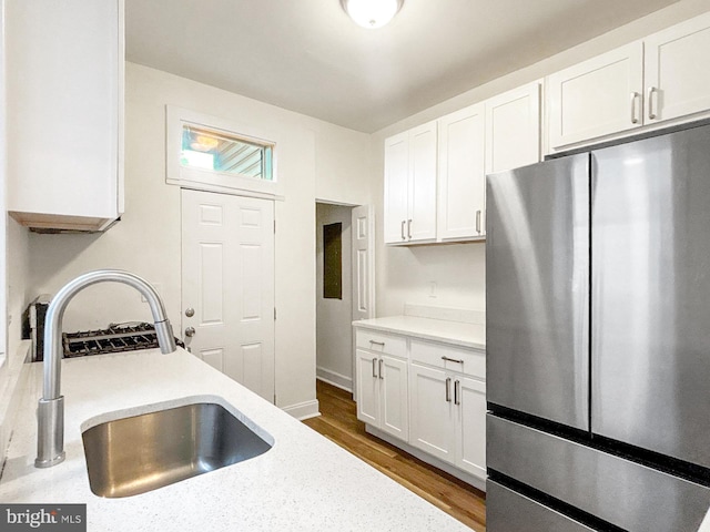 2217 Riggs Ave, Baltimore, MD 21216 - kitchen with freestanding refrigerator, white cabinetry, and dark wood-style flooring