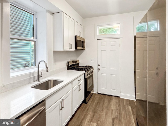 2217 Riggs Ave, Baltimore, MD 21216 - kitchen featuring appliances with stainless steel finishes, wood finished floors, and white cabinets
