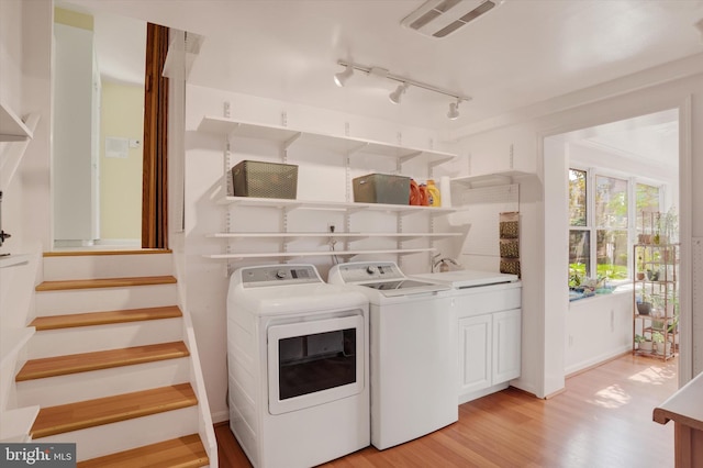 4517 Coventry Rd, Harrisburg, PA 17109 - washroom featuring washing machine and clothes dryer, light wood-style floors, cabinet space, and track lighting