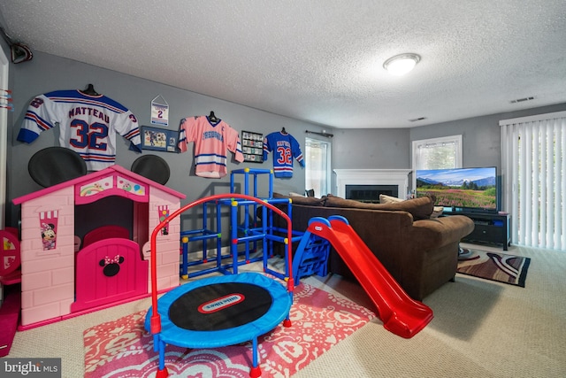 11590 Mohican Rd, Woodbridge, VA 22192 - rec room with carpet flooring, a textured ceiling, and a fireplace
