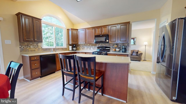 126 Fairbrook Dr, Gilbertsville, PA 19525 - kitchen with black appliances, light countertops, light wood-type flooring, a center island, and vaulted ceiling