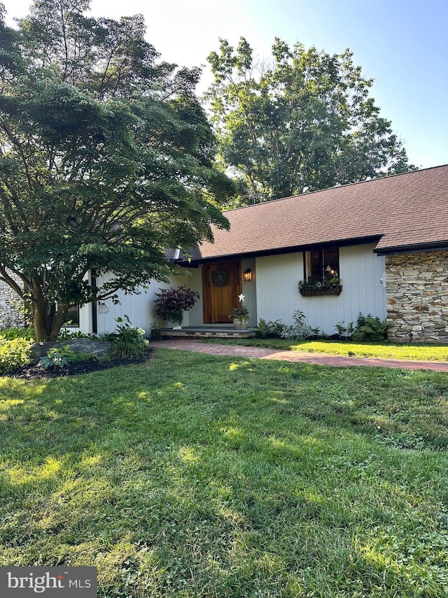 213 Tomahawk Dr, Conestoga, PA 17516 - view of front of home with a front yard, stone siding, and a shingled roof