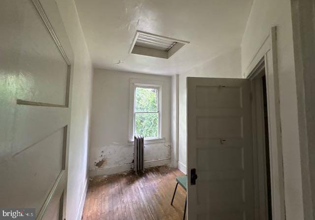 3953 Wilsby Ave, Baltimore, MD 21218 - corridor with wood finished floors, attic access, and radiator heating unit