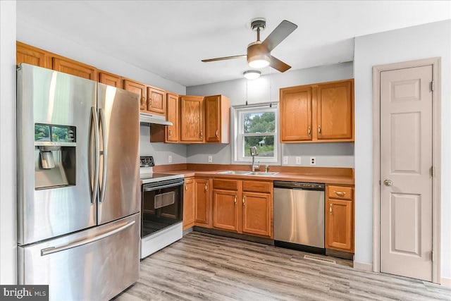 3189 Horseshoe Pike, Honey Brook, PA 19344 - kitchen with stainless steel appliances, under cabinet range hood, a ceiling fan, light wood-style flooring, and brown cabinetry
