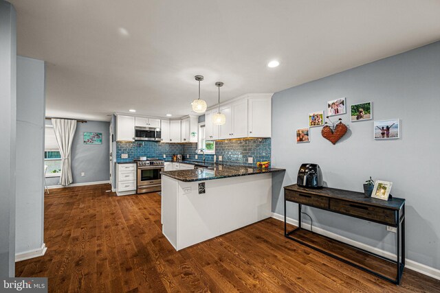 177 Bortondale Rd, Media, PA 19063 - kitchen featuring stainless steel appliances, a peninsula, white cabinetry, backsplash, and dark wood-style flooring