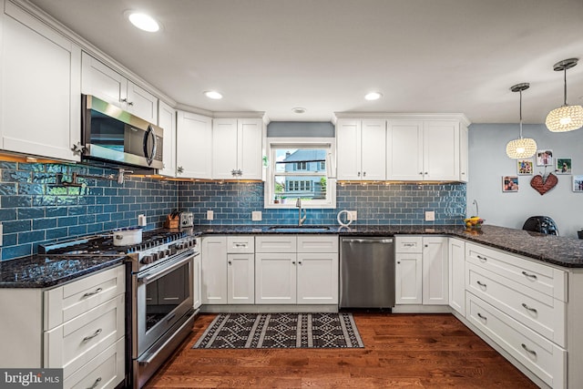 177 Bortondale Rd, Media, PA 19063 - kitchen with stainless steel appliances, a peninsula, white cabinets, dark wood-style flooring, and decorative backsplash