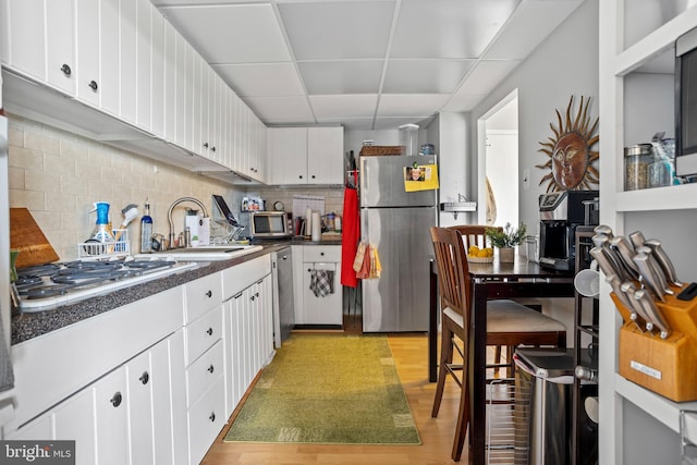 801 Yale Ave Unit 1016, Swarthmore, PA 19081 - kitchen featuring stainless steel appliances, dark countertops, a paneled ceiling, white cabinetry, and tasteful backsplash
