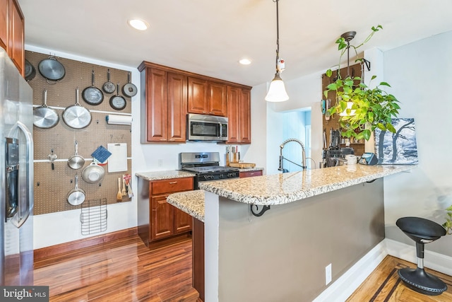 7701 Parkview Rd, Upper Darby, PA 19082 - kitchen with appliances with stainless steel finishes, wood finished floors, brown cabinetry, a peninsula, and recessed lighting
