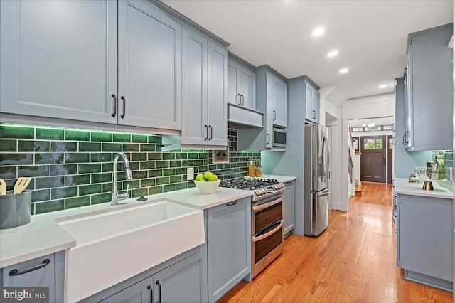 1425 Webster St NW, Washington, DC 20011 - kitchen featuring appliances with stainless steel finishes, gray cabinetry, light wood finished floors, tasteful backsplash, and recessed lighting