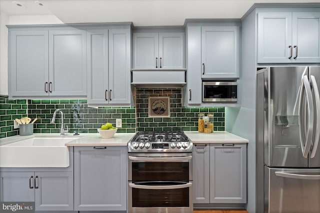 1425 Webster St NW, Washington, DC 20011 - kitchen with appliances with stainless steel finishes, gray cabinets, light countertops, and decorative backsplash