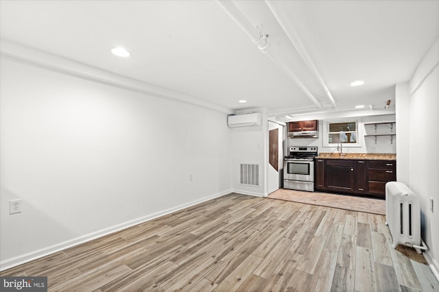 1425 Webster St NW, Washington, DC 20011 - kitchen with electric range, radiator heating unit, an AC wall unit, light wood-style flooring, and recessed lighting