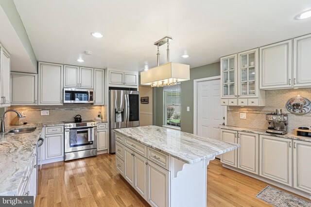8535 Dark Hawk Cir, Columbia, MD 21045 - kitchen with appliances with stainless steel finishes, backsplash, a center island, light wood finished floors, and recessed lighting