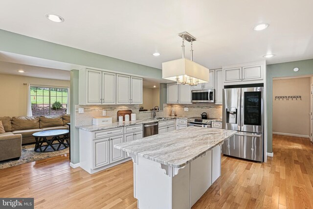 8535 Dark Hawk Cir, Columbia, MD 21045 - kitchen featuring appliances with stainless steel finishes, decorative backsplash, a center island, a chandelier, and recessed lighting