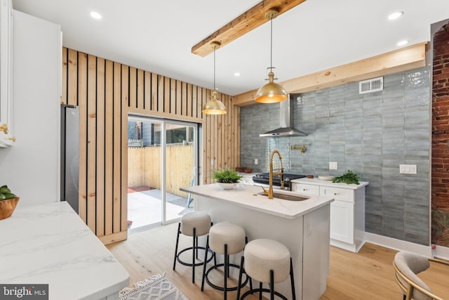 2165 E Gordon St, Philadelphia, PA 19125 - kitchen with wall chimney exhaust hood, light wood finished floors, light stone countertops, white cabinetry, and recessed lighting