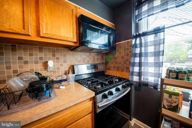 5563 Cedonia Ave, Baltimore, MD 21206 - kitchen featuring gas range, black microwave, plenty of natural light, and light countertops