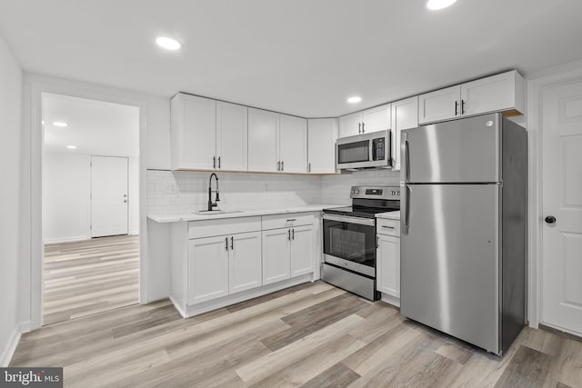 310 Elizabeth St, Middletown, DE 19709 - kitchen featuring appliances with stainless steel finishes, light countertops, white cabinetry, tasteful backsplash, and recessed lighting