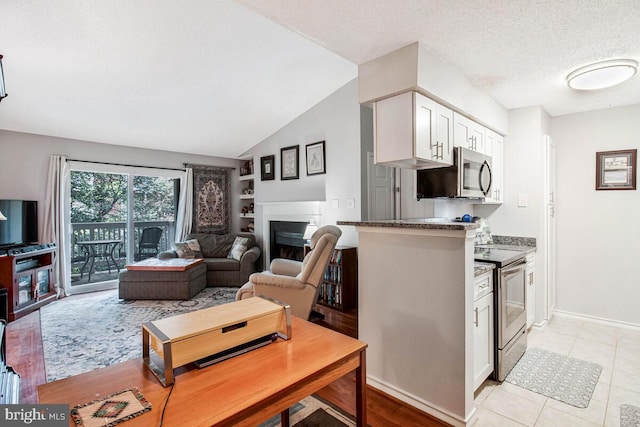 1515 Lincoln Way Unit 304B, Mclean, VA 22102 - kitchen featuring appliances with stainless steel finishes, a fireplace, white cabinetry, light tile patterned floors, and open floor plan