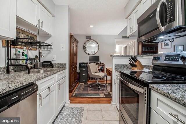 1515 Lincoln Way Unit 304B, Mclean, VA 22102 - kitchen featuring stainless steel appliances, white cabinets, and light stone counters