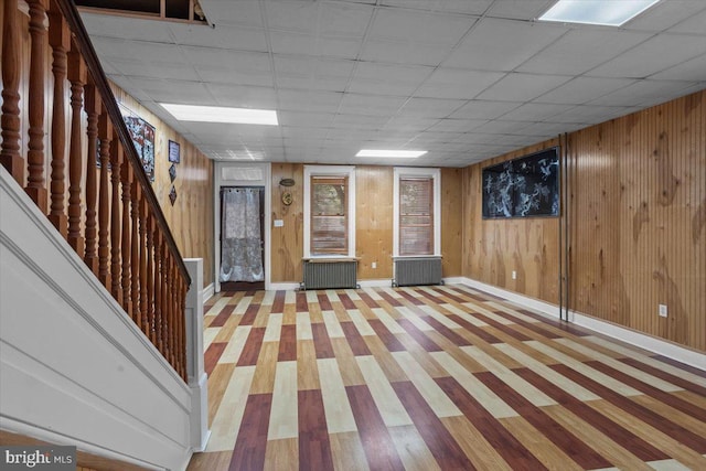 609 E Chestnut St, Lancaster, PA 17603 - finished basement featuring radiator heating unit, stairs, wood finished floors, wooden walls, and a drop ceiling