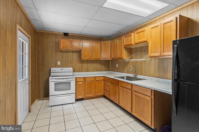 609 E Chestnut St, Lancaster, PA 17603 - kitchen with white range with electric cooktop, freestanding refrigerator, light countertops, light tile patterned flooring, and wooden walls