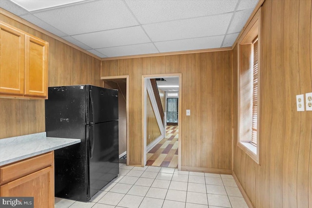 609 E Chestnut St, Lancaster, PA 17603 - kitchen with freestanding refrigerator, light tile patterned floors, wooden walls, a paneled ceiling, and light stone counters