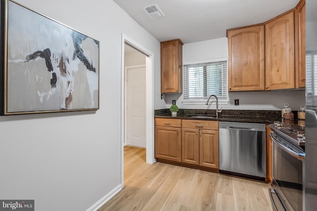 2810 Lee Oaks Pl Unit 302, Falls Church, VA 22046 - kitchen featuring stainless steel appliances, light wood finished floors, dark stone counters, and brown cabinetry