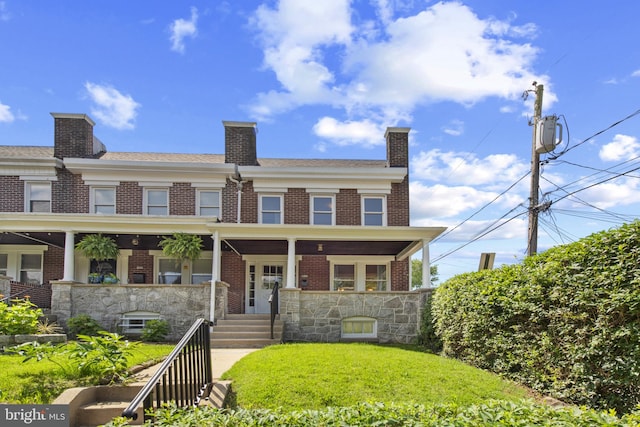 1125 Woodheights Ave, Baltimore, MD 21211 - view of front facade with brick siding, a front lawn, covered porch, and a chimney