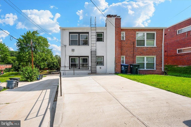 211 Webster St NE, Washington, DC 20011 - back of house with brick siding, a lawn, a chimney, and concrete driveway