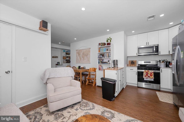 211 Webster St NE, Washington, DC 20011 - kitchen with stainless steel appliances, white cabinetry, light countertops, recessed lighting, and dark wood-type flooring