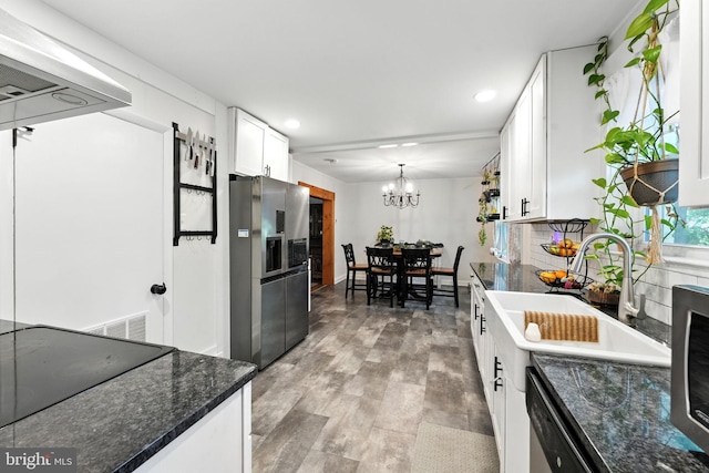 1900 Philadelphia Pike, Claymont, DE 19703 - kitchen with appliances with stainless steel finishes, white cabinetry, a chandelier, recessed lighting, and dark stone counters