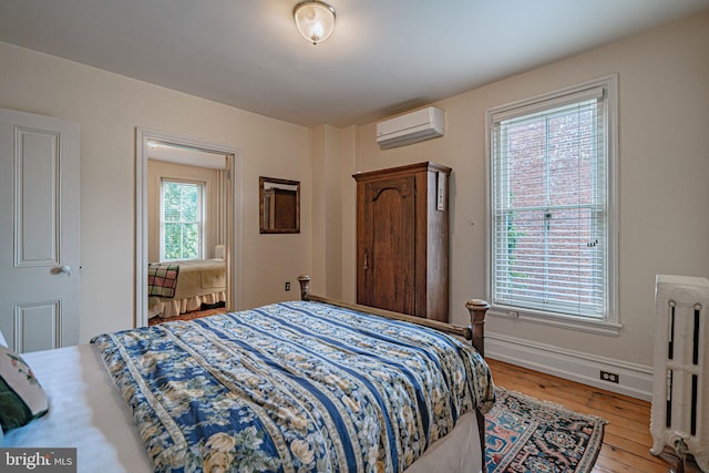 407 N 8th St, Allentown, PA 18102 - bedroom with an AC wall unit, radiator, and light wood-style floors