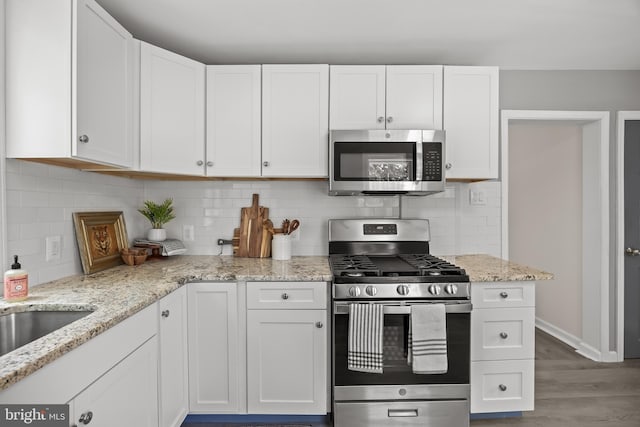 199 Erial, Pine Hill, NJ 08021 - kitchen with appliances with stainless steel finishes, wood finished floors, white cabinets, and light stone counters