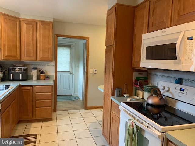 21055 Bayside Ave, Rock Hall, MD 21661 - kitchen featuring white appliances, light tile patterned flooring, light countertops, and brown cabinets