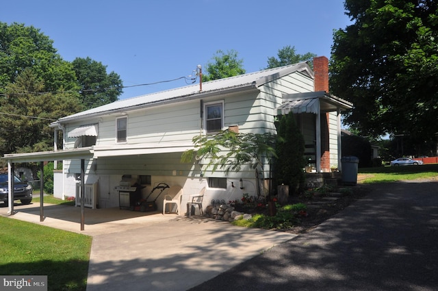 732 Blasser St, Millersburg, PA 17061 - view of side of home featuring a chimney, a carport, a metal roof, and driveway