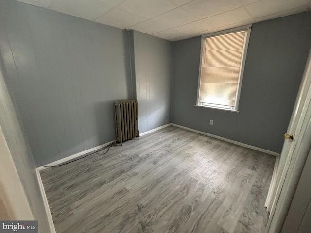 4066 Creston St, Philadelphia, PA 19135 - unfurnished room featuring radiator, wood finished floors, and a drop ceiling